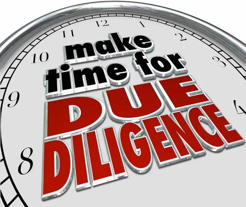 A clock with the phrase, "Make time for due diligence," written on it in black and red letters.