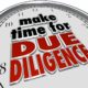 A clock with the phrase, "Make time for due diligence," written on it in black and red letters.