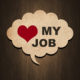 Graphic of a cork board thought bubble in front of a wood grain background with a red heart and the words "my job" in the thought bubble.