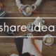 A group of people sit around a wooden conference table with papers, writing utensils, coffees, and a laptop. The words "share ideas" are superimposed over the top of this image.